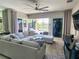 Spacious living room with large sectional sofa, pool view, and modern fireplace at 5013 Sevilla Shores Dr, Wimauma, FL 33598