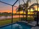 Screened-in pool and patio with sunset view at 5013 Sevilla Shores Dr, Wimauma, FL 33598