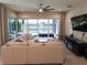 Open living area with sectional sofa, sliding glass doors, and views of the pool and lake at 5013 Sevilla Shores Dr, Wimauma, FL 33598