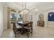 Bright dining room featuring a large table, chandelier, and views to backyard at 5704 Arnie Loop, Lakewood Ranch, FL 34211