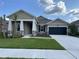 Charming single-story home boasts stone accents, a dark garage door, and freshly landscaped front yard at 17434 Crisp Apple Ln, Land O Lakes, FL 34638