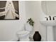 Small bathroom with pedestal sink, toilet, and framed nautical print at 9058 Petty Ln, Lakewood Ranch, FL 34202