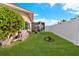 Spacious backyard with grassy lawn, pool equipment, and a white fence at 351 Harbor Psge, Clearwater Beach, FL 33767