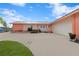 Pink mid-century modern home with attached garage, mature landscaping, and spacious driveway at 351 Harbor Psge, Clearwater Beach, FL 33767