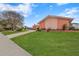 Side view of a pink mid-century modern home with lush lawn and walkway at 351 Harbor Psge, Clearwater Beach, FL 33767