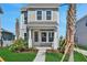 Two-story home with a inviting front porch, neat landscaping, and blue sky at 9019 Rothman Ln, Lakewood Ranch, FL 34240