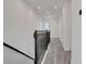 Hallway features dark railing and newel posts and wood-look floor tiles at 9019 Rothman Ln, Lakewood Ranch, FL 34240