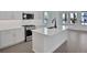 Modern kitchen with stainless steel appliances, a large island with sink, and lots of natural light at 9019 Rothman Ln, Lakewood Ranch, FL 34240