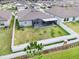 Aerial view of fenced backyard with green grass, a screened patio, and neighboring houses at 13557 Willow Bluestar Loop, Riverview, FL 33579