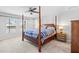 Well-lit bedroom featuring a four-poster bed, neutral carpet, and a ceiling fan at 13557 Willow Bluestar Loop, Riverview, FL 33579