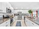 Modern kitchen with white cabinets, granite countertops, and stainless appliances at 13557 Willow Bluestar Loop, Riverview, FL 33579