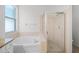 Well-lit bathroom with large soaking tub and glass-enclosed shower at 1652 Open Field Loop, Brandon, FL 33510
