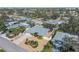 Aerial shot of a single-story home featuring a gray roof, a screened in pool, and tasteful landscaping at 909 Dawn St, Venice, FL 34285