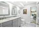 Bathroom featuring dual sinks, granite countertops, modern fixtures, and walk-in shower at 909 Dawn St, Venice, FL 34285