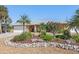 Inviting single-story home showcases lush landscaping with gravel, rock border, and mature palm trees at 909 Dawn St, Venice, FL 34285