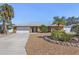 Charming single-story home featuring desert landscaping, a two-car garage, and mature palm trees at 909 Dawn St, Venice, FL 34285