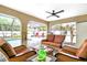 Comfortable patio seating with ceiling fan overlooks the inviting pool and lush landscaping at 909 Dawn St, Venice, FL 34285