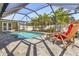 Beautiful backyard pool area features screened enclosure and comfortable lounge seating at 909 Dawn St, Venice, FL 34285