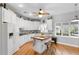 Well-lit kitchen with white cabinets, wood floors, and a central island for food preparation at 12631 Timber Run, Dade City, FL 33525