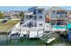 The beautiful back of the house, including a private boat lift and waterfront access on a sunny day at 13737 Victor Ave, Hudson, FL 34667