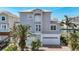 Charming two-story home showcasing architectural details and a well-maintained yard with mature palm trees at 13737 Victor Ave, Hudson, FL 34667