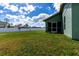 Spacious backyard featuring a green lawn, white fence, and a screened-in lanai at 4154 Duluth Ter, North Port, FL 34286