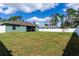 Large backyard with green grass, bordered by a white fence and mature trees at 4154 Duluth Ter, North Port, FL 34286