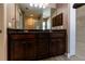 Bathroom vanity with a granite countertop, dual sinks, dark cabinetry, and large mirror at 4154 Duluth Ter, North Port, FL 34286