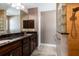 Bathroom with glass block window, dark cabinetry, granite countertop, and updated shower head at 4154 Duluth Ter, North Port, FL 34286