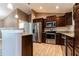 Modern kitchen featuring granite countertops, stainless appliances, and dark wood cabinets at 4154 Duluth Ter, North Port, FL 34286