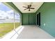 Screened in patio with green walls, fan and views of the green grass in the backyard at 4154 Duluth Ter, North Port, FL 34286