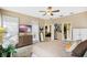 Comfortable bedroom featuring a ceiling fan, carpet, and a view into the en-suite bathroom and living area at 3203 Sago Point Ct, Land O Lakes, FL 34639