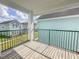 A covered balcony with black railings and a wood floor overlooks the community lawn at 4007 Bangalow Palm Ct # 4007, Tampa, FL 33624