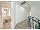 Upstairs hallway leading to a bathroom, featuring wood-style flooring and a modern aesthetic at 4007 Bangalow Palm Ct # 4007, Tampa, FL 33624