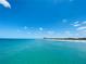Wide view of a white sand beach and clear blue water under a partly cloudy sky at 933 Harbor S Dr, Venice, FL 34285