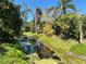 A tranquil creek meanders through the lush green landscape, offering a serene and private setting at 933 Harbor S Dr, Venice, FL 34285