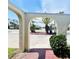 Home entryway with unique archway framing tropical plants and a street view in a sunny landscape at 933 Harbor S Dr, Venice, FL 34285
