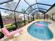 A screened in swimming pool, patio, lounge chair, fenced yard, and privacy landscaping at 933 Harbor S Dr, Venice, FL 34285