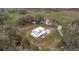 Aerial view showcasing the home with a metal roof, surrounding landscape, and winding driveway at 15734 Old Mill Pond Rd, Dade City, FL 33523