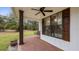 Charming front porch features brick flooring, stained wood columns and swing at 15734 Old Mill Pond Rd, Dade City, FL 33523