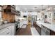 Modern kitchen featuring stainless steel appliances, farmhouse sink, and contrasting white and dark wood cabinetry at 15734 Old Mill Pond Rd, Dade City, FL 33523