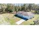 Birds-eye view of a single-Gathering home with long drive and surrounding trees at 33021 Ranch Rd, Dade City, FL 33523