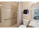 Bathroom featuring accessible grab bars, tiled shower, and a neutral colored walls at 33021 Ranch Rd, Dade City, FL 33523