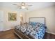 Serene bedroom featuring wood floors, natural light, and a queen bed with patterned bedding at 33021 Ranch Rd, Dade City, FL 33523