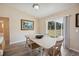 Bright dining space with wood-look floors, white table, and a view of the backyard at 33021 Ranch Rd, Dade City, FL 33523