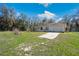 View of the home's white exterior, paved driveway, and grassy front lawn at 33021 Ranch Rd, Dade City, FL 33523