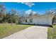 A front exterior view of the house features a white exterior and a concrete driveway at 33021 Ranch Rd, Dade City, FL 33523