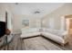 Bright living room featuring neutral walls, ceiling fan, and an L-shaped white couch over a stylish area rug at 33021 Ranch Rd, Dade City, FL 33523