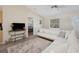 Cozy living room featuring a plush rug, white sectional, and a view into the bedroom at 33021 Ranch Rd, Dade City, FL 33523