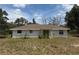 Well-kept rear exterior of home, showcasing a covered porch and generous backyard at 33021 Ranch Rd, Dade City, FL 33523